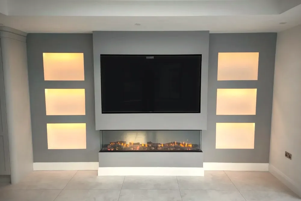 Grey media wall with six backlit recessed niches either side of a wall mounted television above a linear fireplace