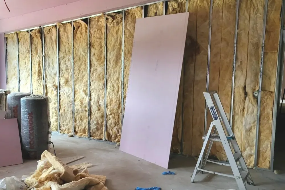 Metal stud partition wall filled with mineral wool insulation, part boarded with fire rated plasterboard