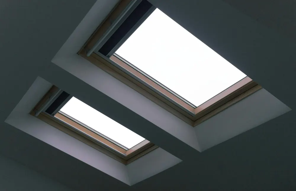 Two rooflights set into a dark grey vaulted plasterboard ceiling with crisp square reveals